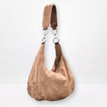 sand tan  suede handbag with a strap on a light gray background